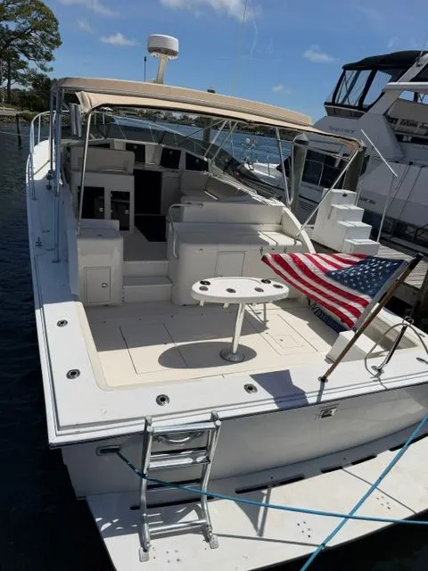 Slide: The Image of A 1990 Topaz Royale docked. It features an open deck with an American flag. - 4