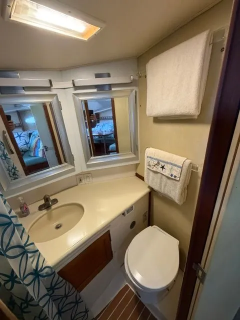 Slide: The Image of The image shows a boat bathroom with a sink, toilet, and mirrors. - 10