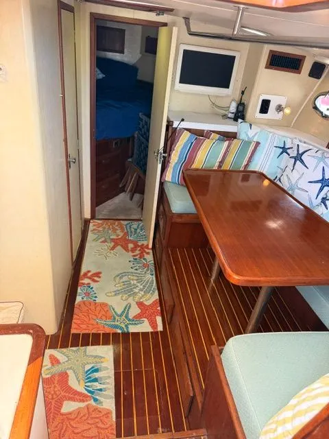 Slide: The Image of Interior of a 1990 Topaz Royale with wooden flooring, colorful cushions, and a table. - 11