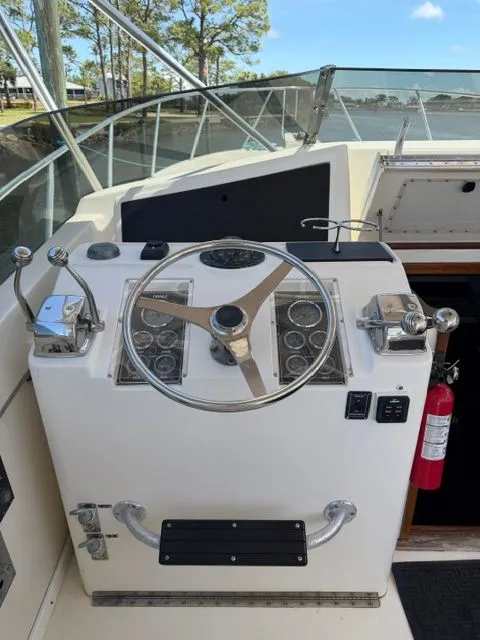 Slide: The Image of The image shows a boat's helm with a large steering wheel and various instruments. - 6