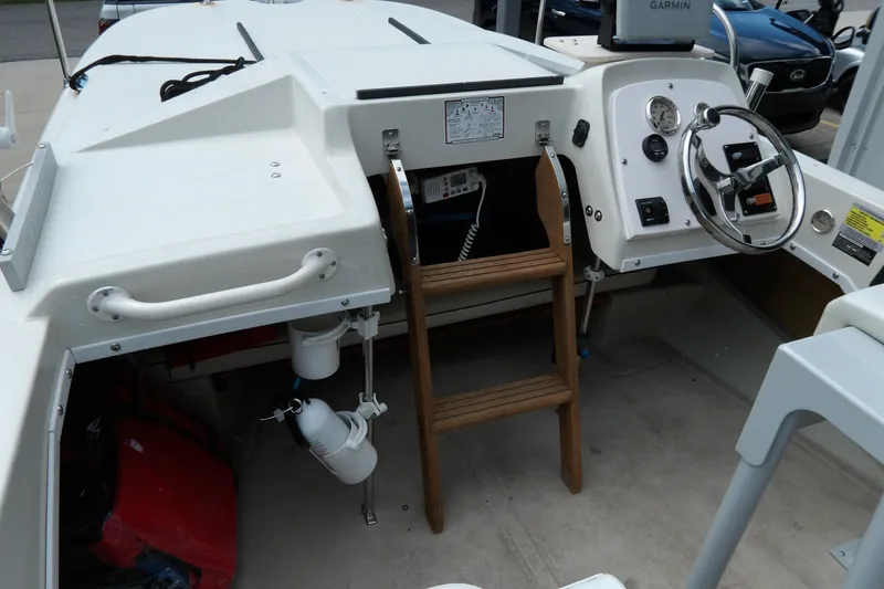 Slide: The Image of 1978 Boston Whaler 21 Revenge boat interior with steering wheel and wooden ladder. - 12