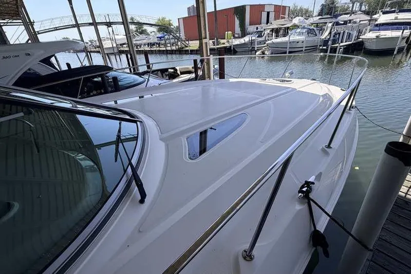 Slide: The Image of 2011 Sea Ray Sundancer 370 docked at marina, showcasing sleek design and spacious deck. - 3