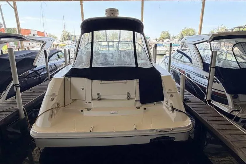 Slide: The Image of 2011 Sea Ray Sundancer 370 docked in a marina, rear view with covered cockpit. - 5
