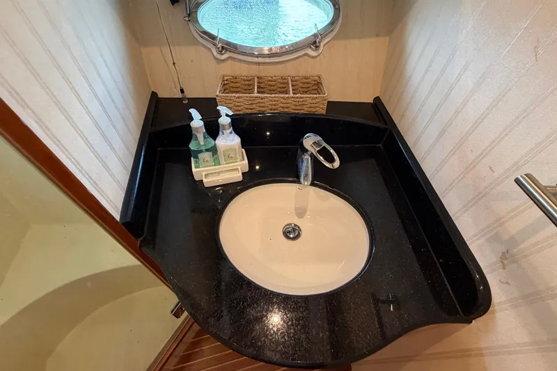 Slide: The Image of Elegant bathroom sink on 2005 Ocean Alexander 48 Altus yacht, featuring black countertop and modern faucet. - 65