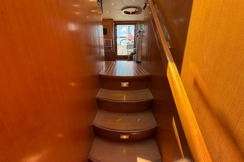 Slide: The Image of Staircase inside 2005 Ocean Alexander 48 Altus yacht, featuring wooden steps and handrail. - 52