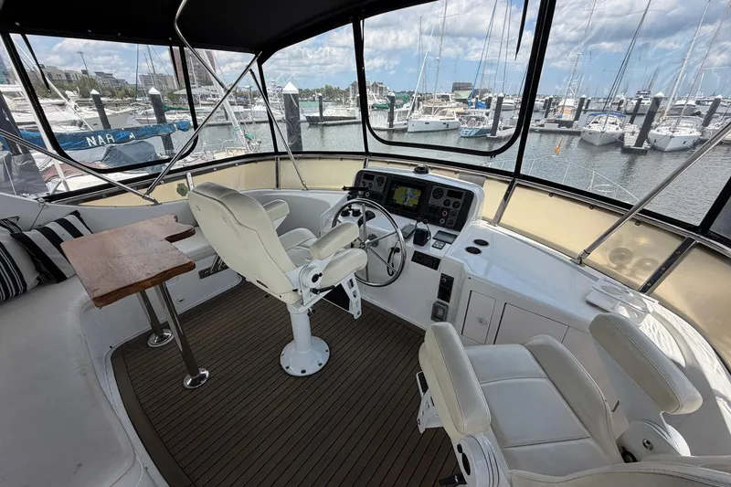 Slide: The Image of Cockpit of 2005 Ocean Alexander 48 Altus yacht with helm, seating, and marina view. - 27