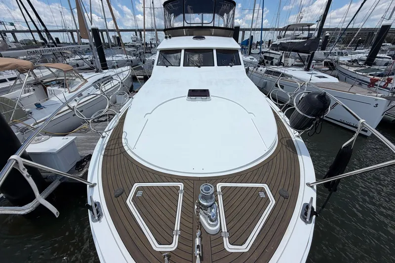 Slide: The Image of 2005 Ocean Alexander 48 Altus yacht docked at marina, showcasing sleek design and spacious deck. - 18
