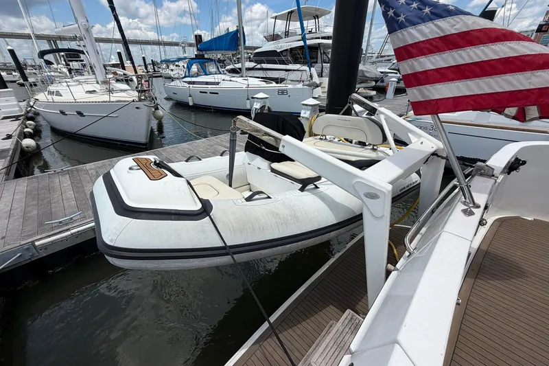 Slide: The Image of Docked Ocean Alexander 48 Altus yacht with American flag, featuring a small inflatable boat. - 98