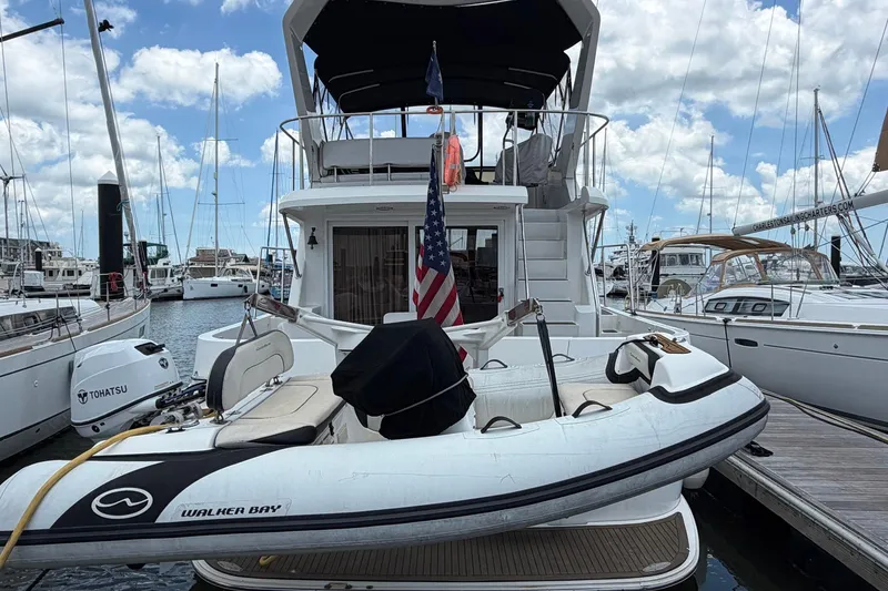 Slide: The Image of 2005 Ocean Alexander 48 Altus yacht docked with inflatable boat and American flag. - 9