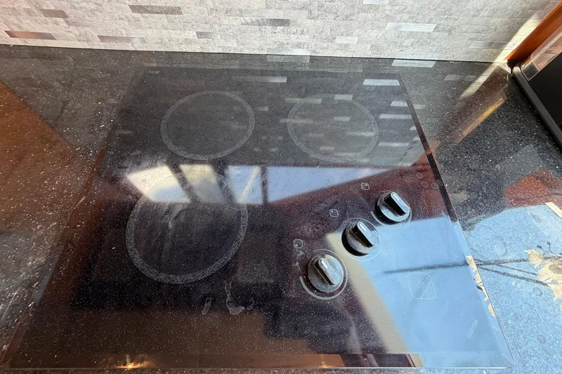 Slide: The Image of Glass stovetop with four burners and control knobs on Ocean Alexander 48 Altus, 2005 model. - 48