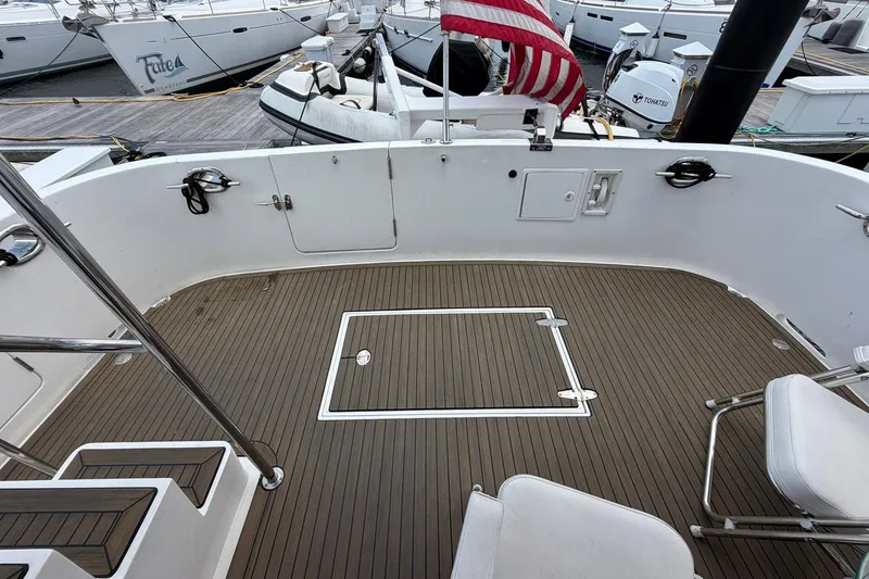 Slide: The Image of Deck view of 2005 Ocean Alexander 48 Altus yacht, featuring teak flooring and American flag. - 23