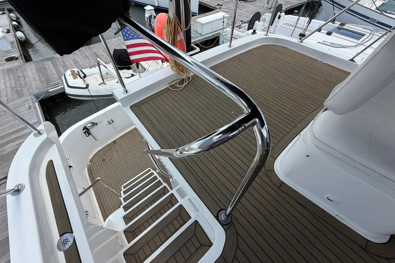 Slide: The Image of Deck view of 2005 Ocean Alexander 48 Altus yacht with American flag and marina backdrop. - 30