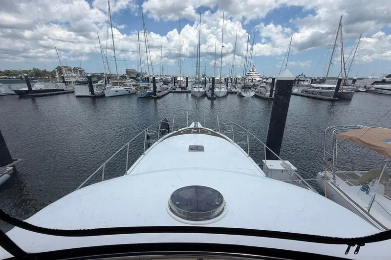 Slide: The Image of Ocean Alexander 48 Altus yacht docked at marina, surrounded by sailboats under a cloudy sky. - 34