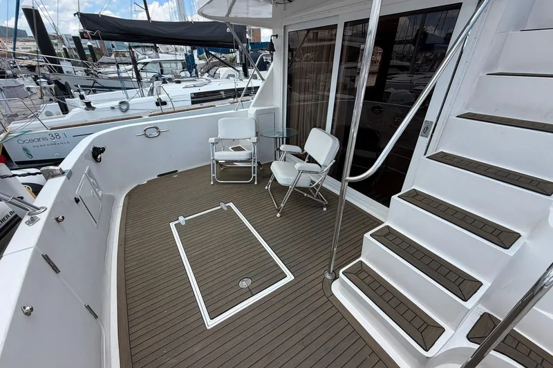 Slide: The Image of 2005 Ocean Alexander 48 Altus yacht deck with seating and stairs, docked at marina. - 24