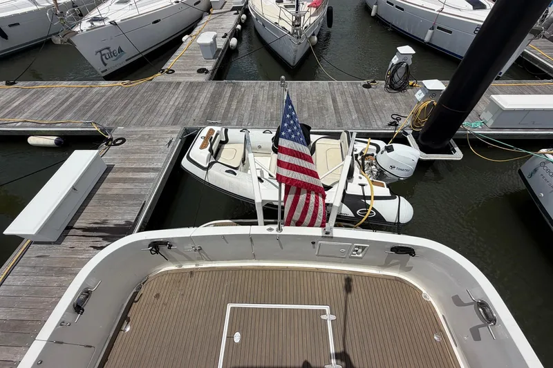 Slide: The Image of 2005 Ocean Alexander 48 Altus yacht docked with American flag and tender boat. - 32