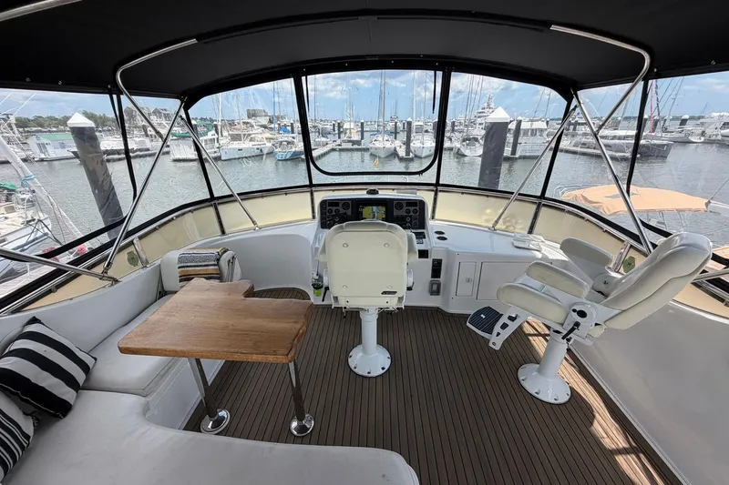 Slide: The Image of Cockpit of 2005 Ocean Alexander 48 Altus yacht with helm, seating, and marina view. - 26