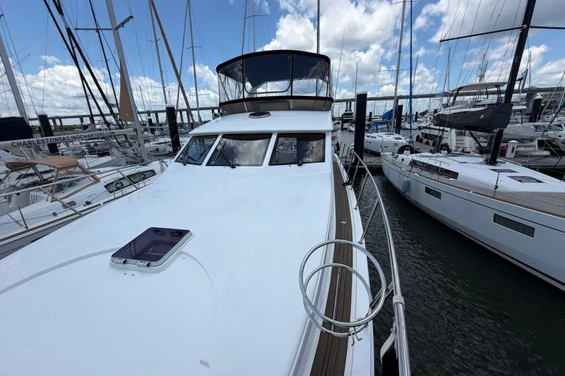 Slide: The Image of 2005 Ocean Alexander 48 Altus yacht docked at marina, surrounded by sailboats under a cloudy sky. - 19