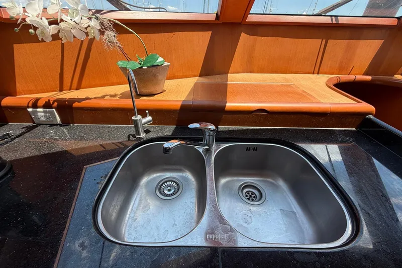 Slide: The Image of Stainless steel sink in 2005 Ocean Alexander 48 Altus yacht kitchen, with wooden countertop and orchid. - 46