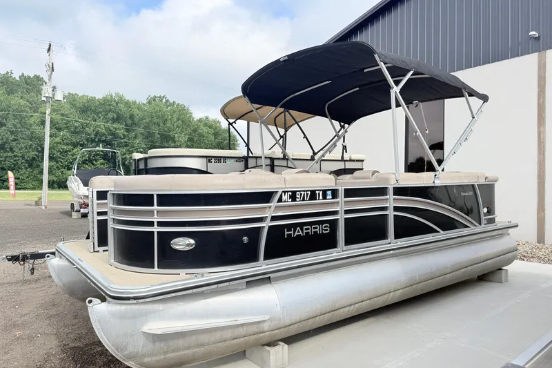 Slide: The Image of 2017 Harris Super Sunliner 200 pontoon boat with canopy, parked outdoors. - 2