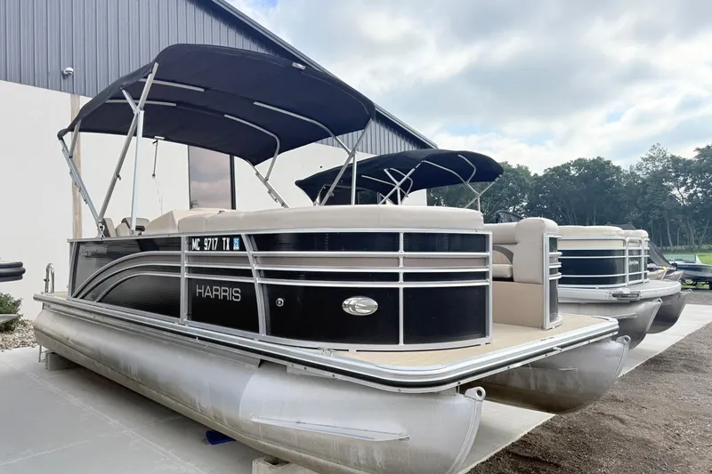 Slide: The Image of 2017 Harris Super Sunliner 200 pontoon boats with canopies, parked outdoors. - 1