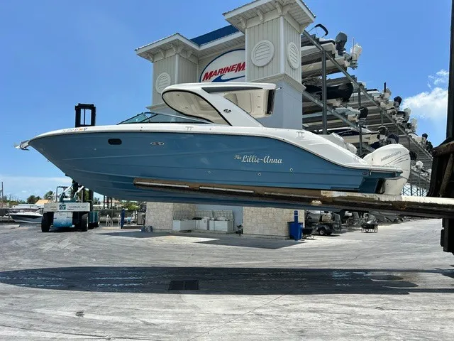 Slide: The Image of A 2021 Sea Ray SLX 310 Outboard is held by a forklift at a marina. - 35