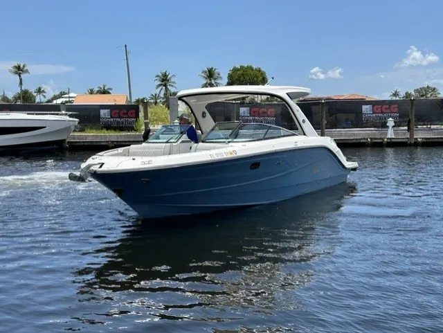 Slide: The Image of Sea Ray SLX 310 Outboard 2021 on calm water with palm trees in the background. - 25