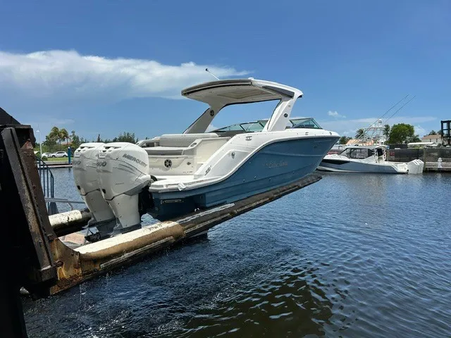 Slide: The Image of A 2021 Sea Ray SLX 310 Outboard being launched, featuring a blue hull and twin outboard engines. - 30