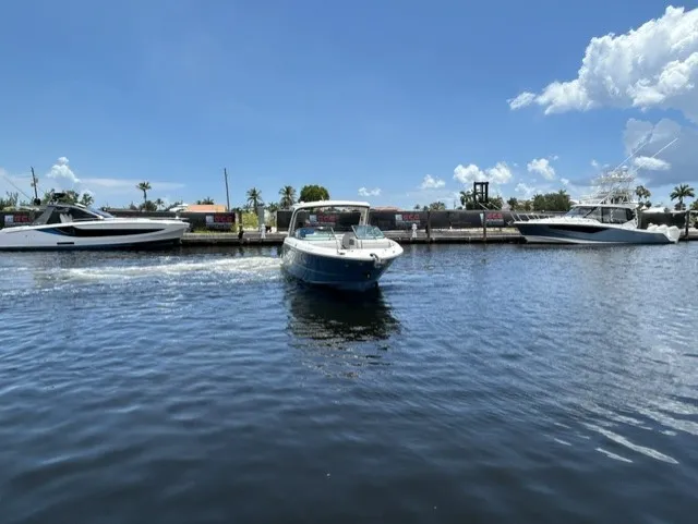Slide: The Image of Sea Ray SLX 310 Outboard 2021 on calm water, surrounded by other boats. - 24