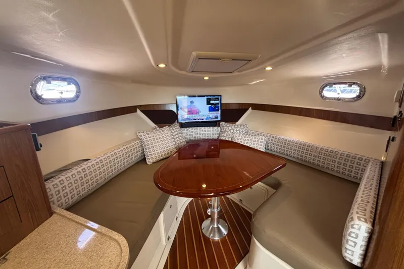 Slide: The Image of 2012 Pursuit 345 OS Forward settee with electrically actuated table top that lowers to form a large berth - 36