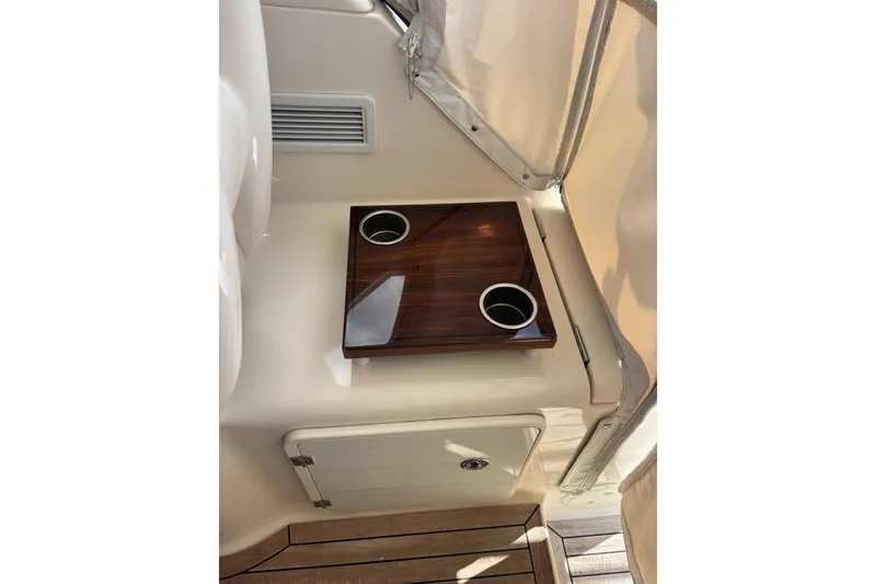 Slide: The Image of 2012 Pursuit OS 345 Offshore boat interior with wooden cup holder and storage compartment. - 13