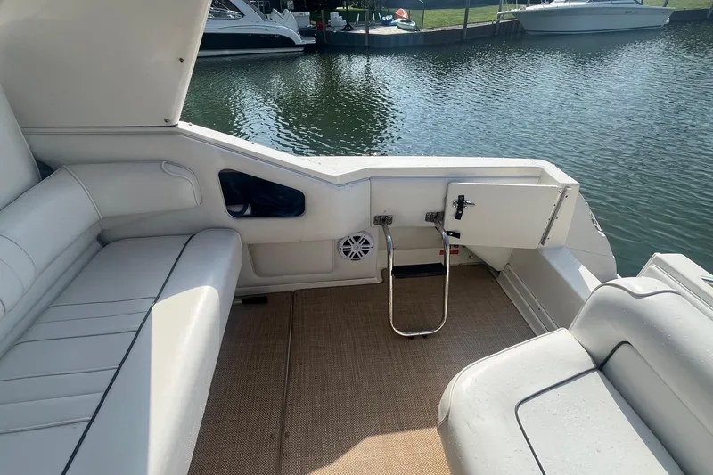 Slide: The Image of 1994 Sea Ray 330 Express Cruiser interior with white seating and open water view. - 7
