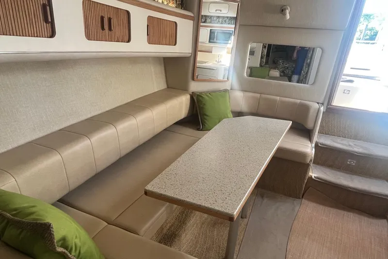 Slide: The Image of Interior of 1994 Sea Ray 330 Express Cruiser with beige seating and green cushions. - 22