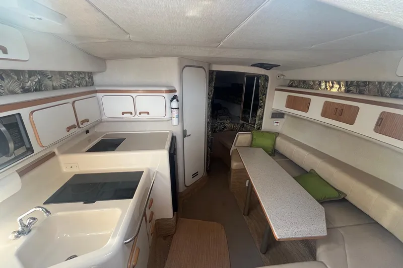 Slide: The Image of Interior of a 1994 Sea Ray 330 Express Cruiser with kitchen and seating area. - 21