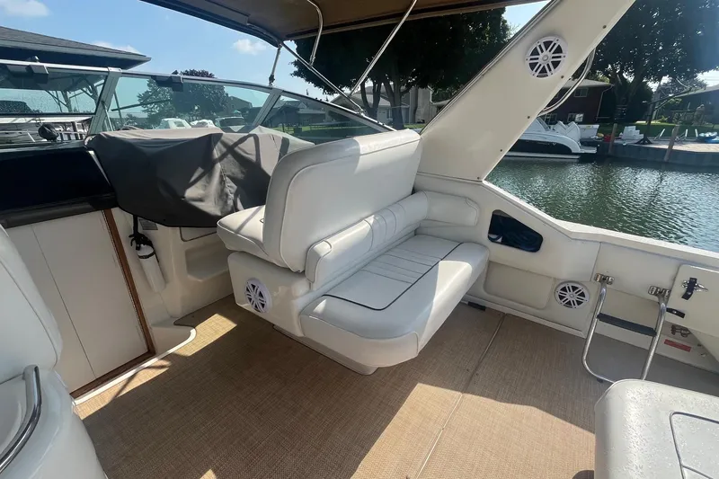 Slide: The Image of 1994 Sea Ray 330 Express Cruiser interior with white seating and waterfront view. - 10
