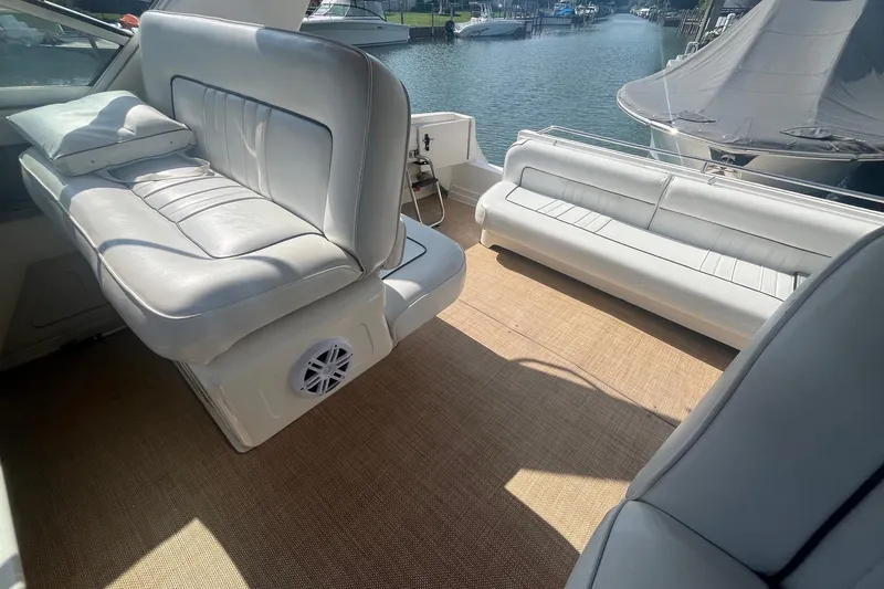 Slide: The Image of 1994 Sea Ray 330 Express Cruiser interior with white seating and waterfront view. - 9