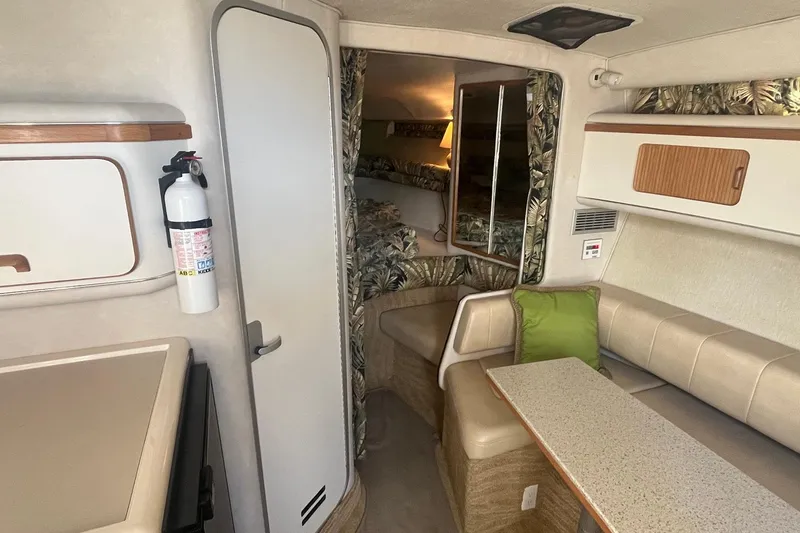 Slide: The Image of 1994 Sea Ray 330 Express Cruiser interior with seating, table, and fire extinguisher. - 24