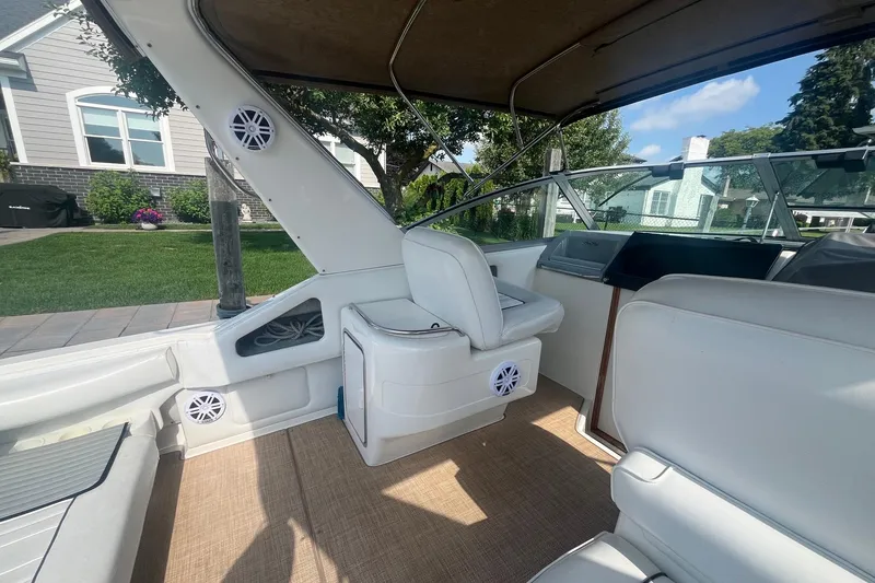 Slide: The Image of Interior of a 1994 Sea Ray 330 Express Cruiser with white seating and speakers. - 11