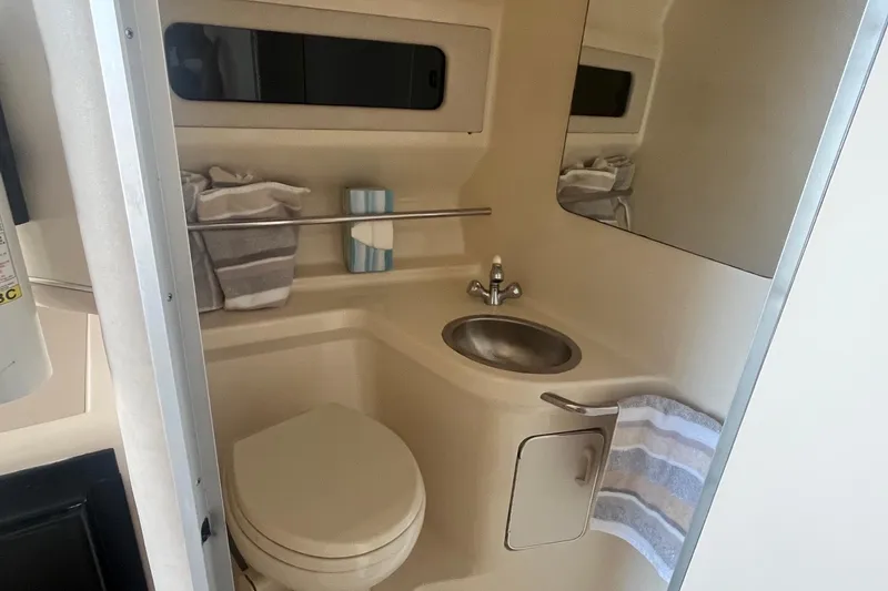Slide: The Image of 1994 Sea Ray 330 Express Cruiser bathroom with sink, toilet, and striped towels. - 31
