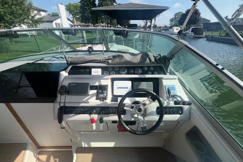 Slide: The Image of 1994 Sea Ray 330 Express Cruiser helm with navigation equipment and steering wheel. - 13