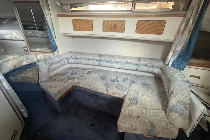 Slide: The Image of Interior of 1993 Sea Ray Sundancer 330 with patterned seating and wooden storage cabinets. - 13