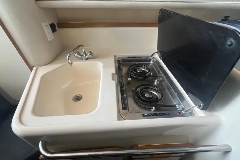 Slide: The Image of 1993 Sea Ray Sundancer 330 galley with sink and dual-burner stove. - 17