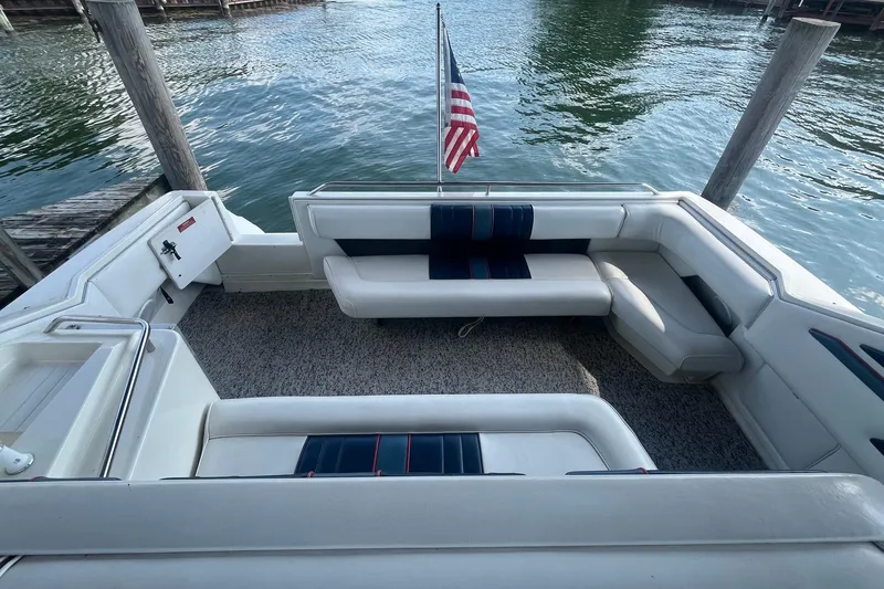 Slide: The Image of 1993 Sea Ray Sundancer 330 boat interior with seating, docked by the water. - 4