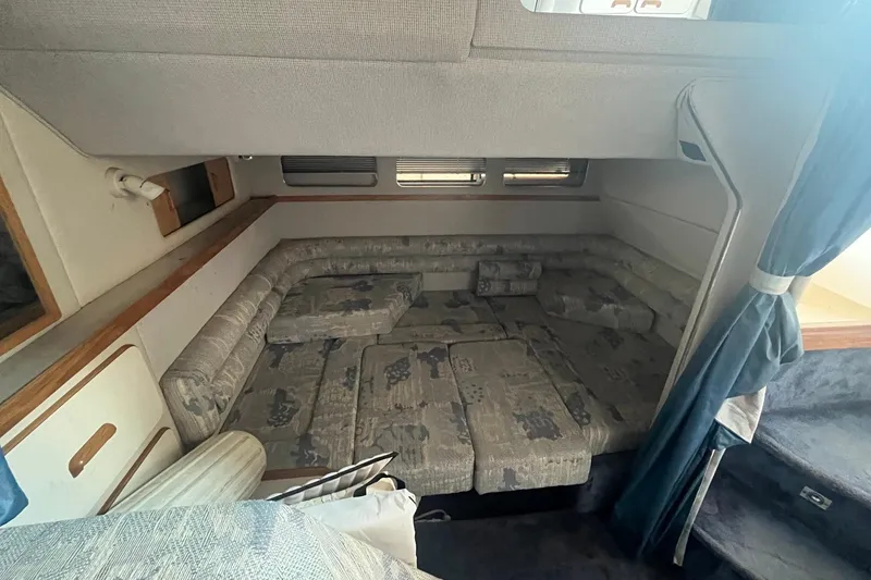 Slide: The Image of Interior cabin of 1993 Sea Ray Sundancer 330 with cushioned seating and blue curtains. - 15