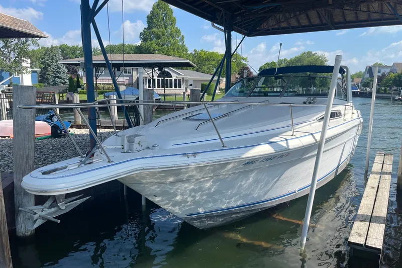 The Image of 1993 Sea Ray Sundancer 330 docked in a marina under a covered structure. - 0