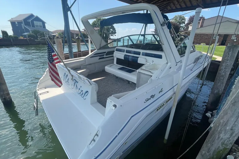 Slide: The Image of 1993 Sea Ray Sundancer 330 docked, featuring spacious seating and American flag. - 2