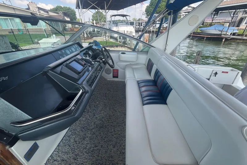 Slide: The Image of 1993 Sea Ray Sundancer 330 cockpit with helm, seating, and waterfront view. - 7