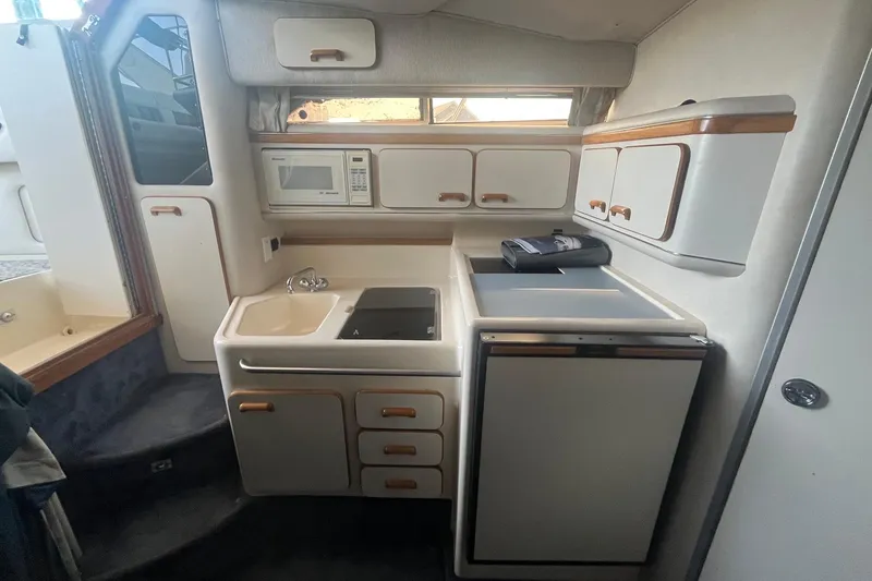 Slide: The Image of 1993 Sea Ray Sundancer 330 boat kitchen with sink, stove, microwave, and refrigerator. - 16
