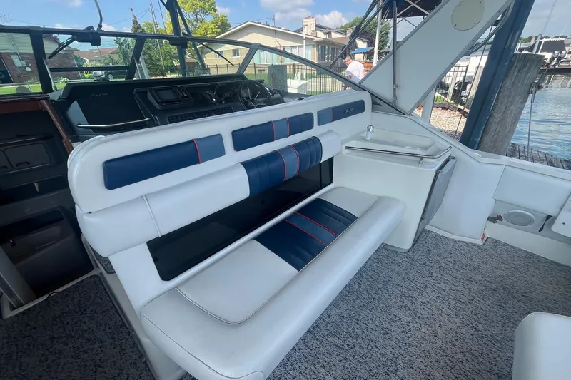 Slide: The Image of 1993 Sea Ray Sundancer 330 interior with blue and white seating, dockside view. - 5