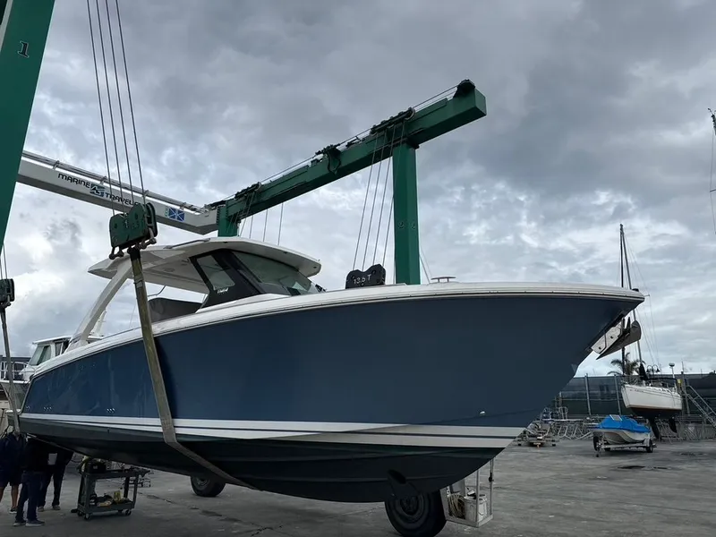 Slide: The Image of A 2024 Tiara Yachts 34 LS being lifted out of the water by a crane. - 1
