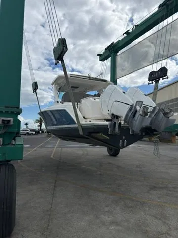 Slide: The Image of A 2024 Tiara Yachts 34 LS being lifted out of the water by a crane. - 2